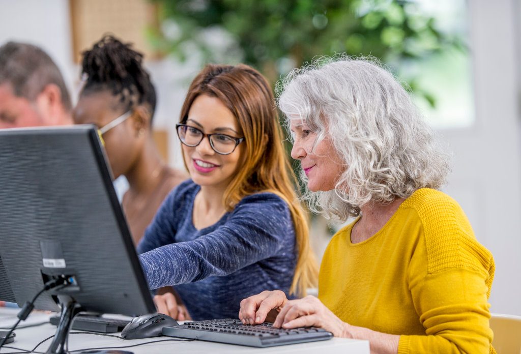 Twee vrouwen kijken naar beeldscherm.