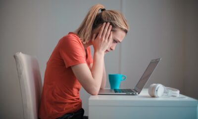 Vrouw kijkt gefrustreerd naar laptop