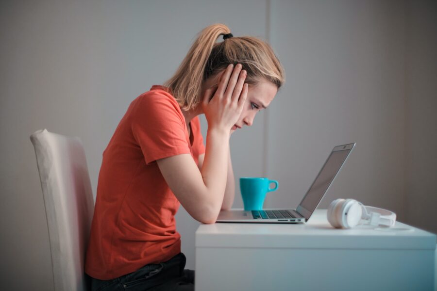 Vrouw kijkt gefrustreerd naar laptop