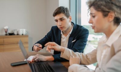 2 mensen achter een laptop, kijken wijzend naar het scherm