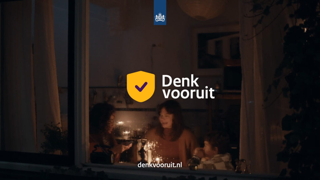 Campagnebeeld Denk vooruit met gezin bij kaarslicht en overheidsschild.